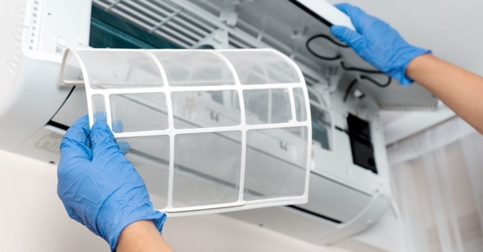 man cleaning AC filter