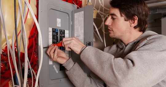 man troubleshooting electrical panel